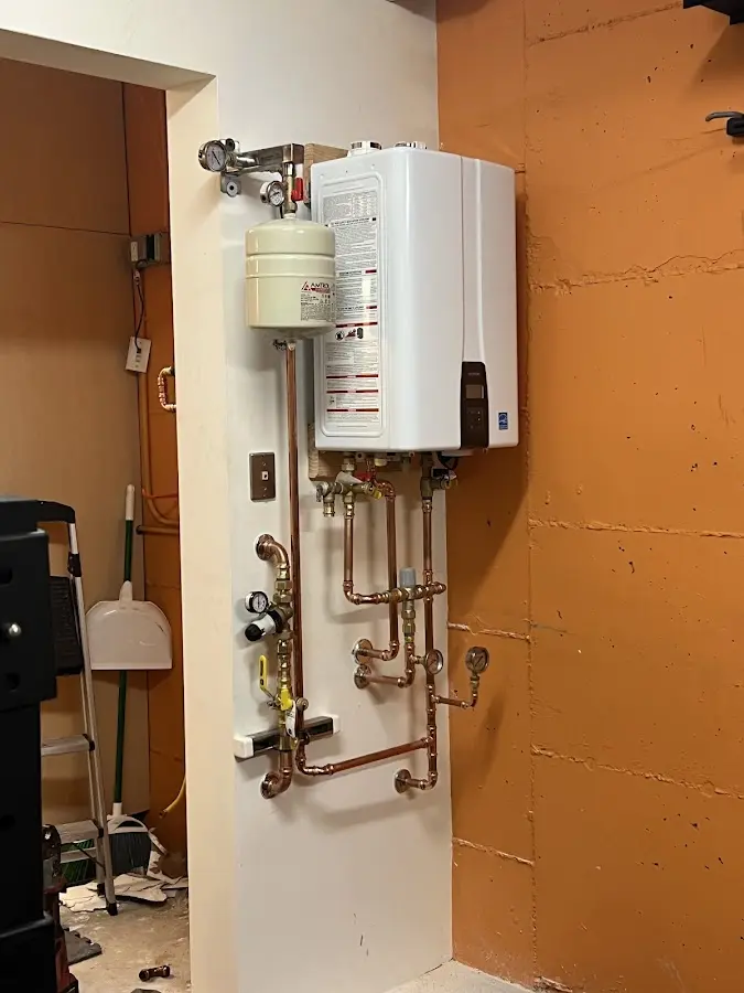 Plumbing technician inspecting water heater connections in Oakwood